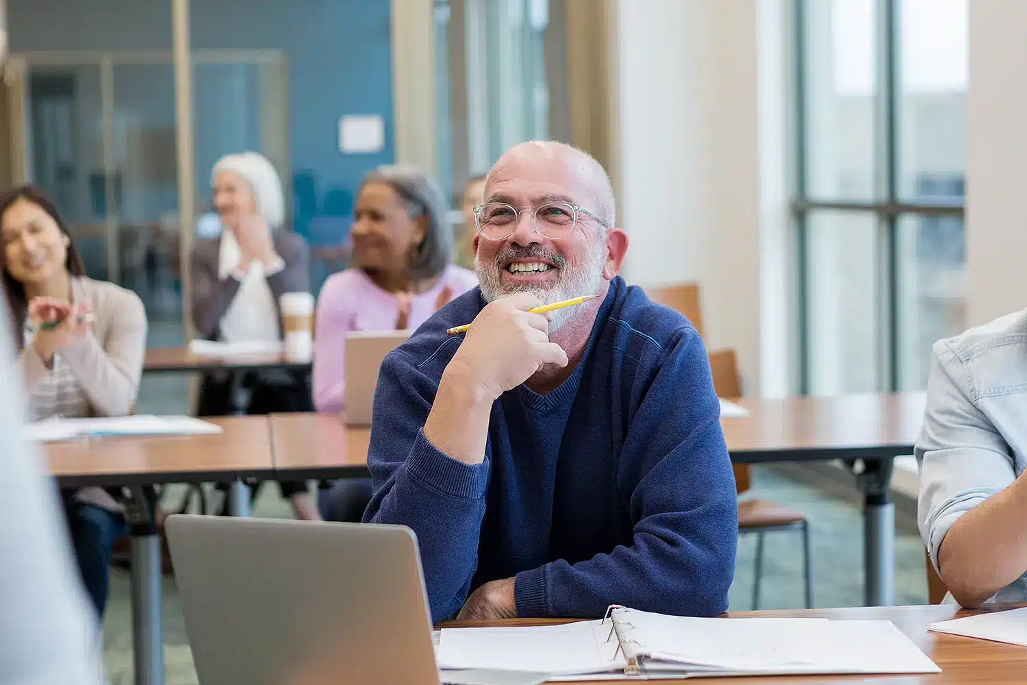 Adult sitting in a classroom and laughing